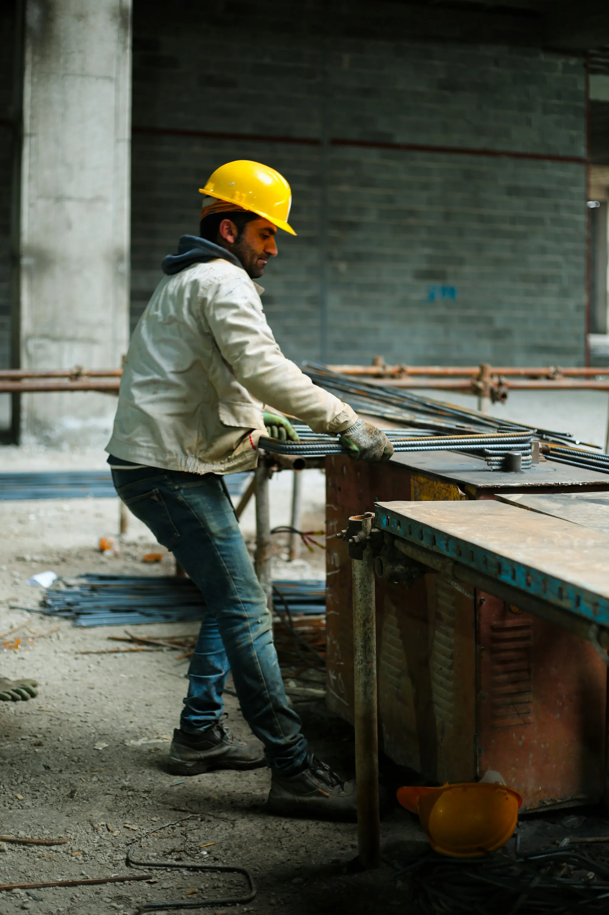 Worker cutting and bending rebar on a job site